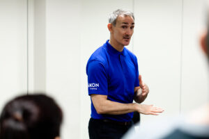 James in blue polo shirt chatting to learners on a course. conflict resolution training.