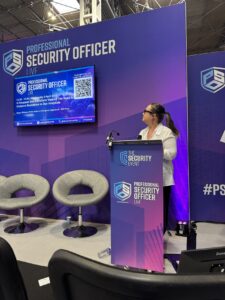 One of the speakers at a lectern looking up at a screen behind her.