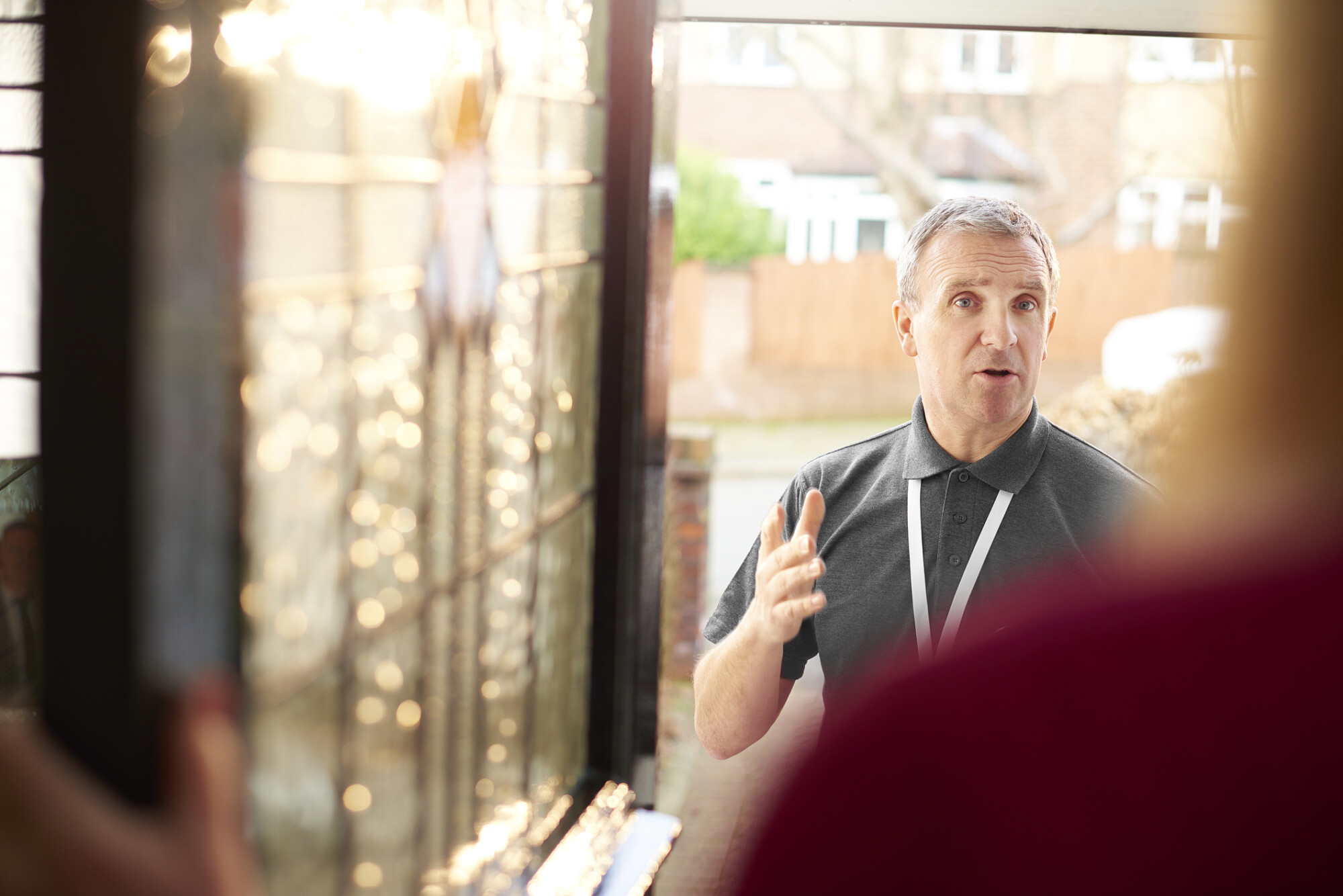 Individual lone worker talking to a client in the doorway.